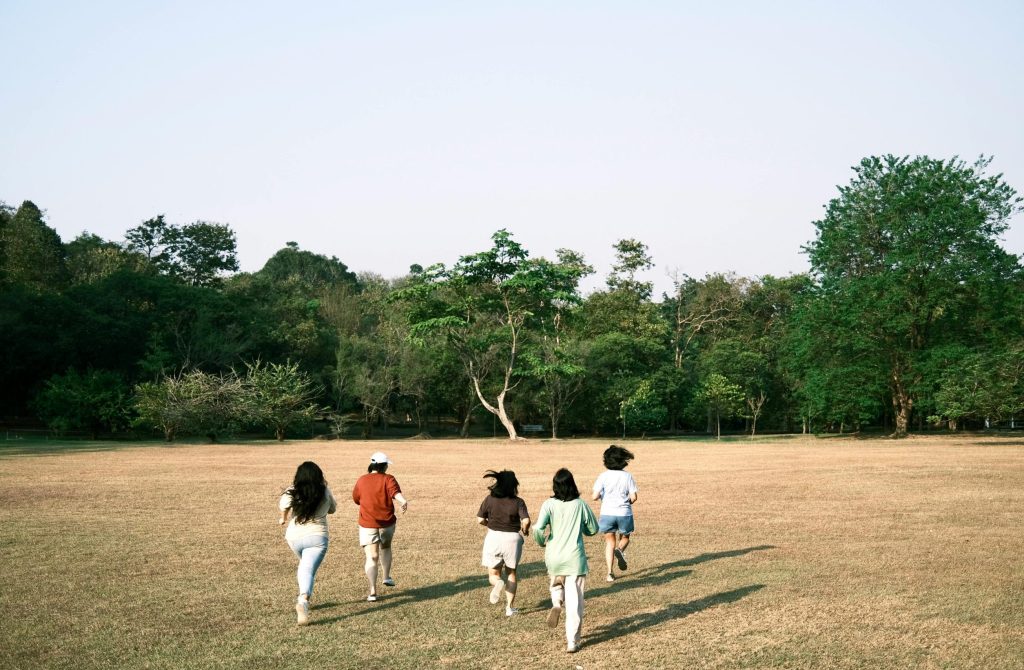A group of teenagers running in a park in Surabaya, Indonesia. Outdoor fun and friendship.